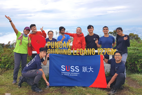 Exhausted but triumphant faces of SUSS students at the summit of Gunung Ledang.