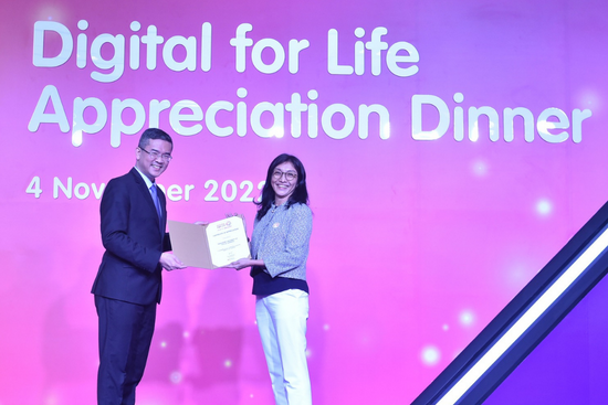 SUSS representative Ms Chia Ming Huei (Specialist, Office of Service-Learning) receiving a certificate of appreciation from Mr Lew Chuen Hong (Chief Executive Officer, Infocomm Media Development Authority) during the Digital for Life Appreciation Dinner.