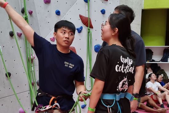 Darren, ODA IG EXCO member (left), guiding a participant on how they should climb a rock wall.