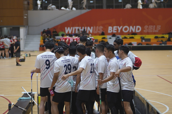 SUSS floorball men’s team huddle before the start of their match against SIT, where they scored 5-1.