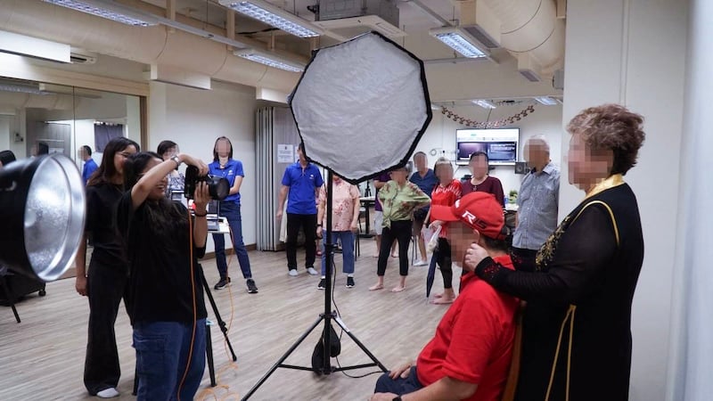 PDIG-member-taking-a-photo-of-an-elderly-couple-(side view)