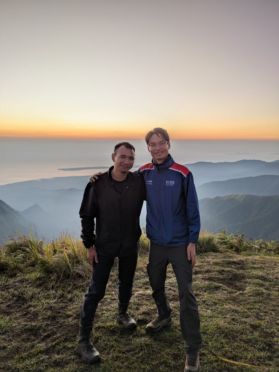 Tiboleng Karl Jude and his roommate for the trip, Fam Yu Xiang, at the summit of Pergasingan Hill, with mountain peaks and a breathtaking horizon in the background.