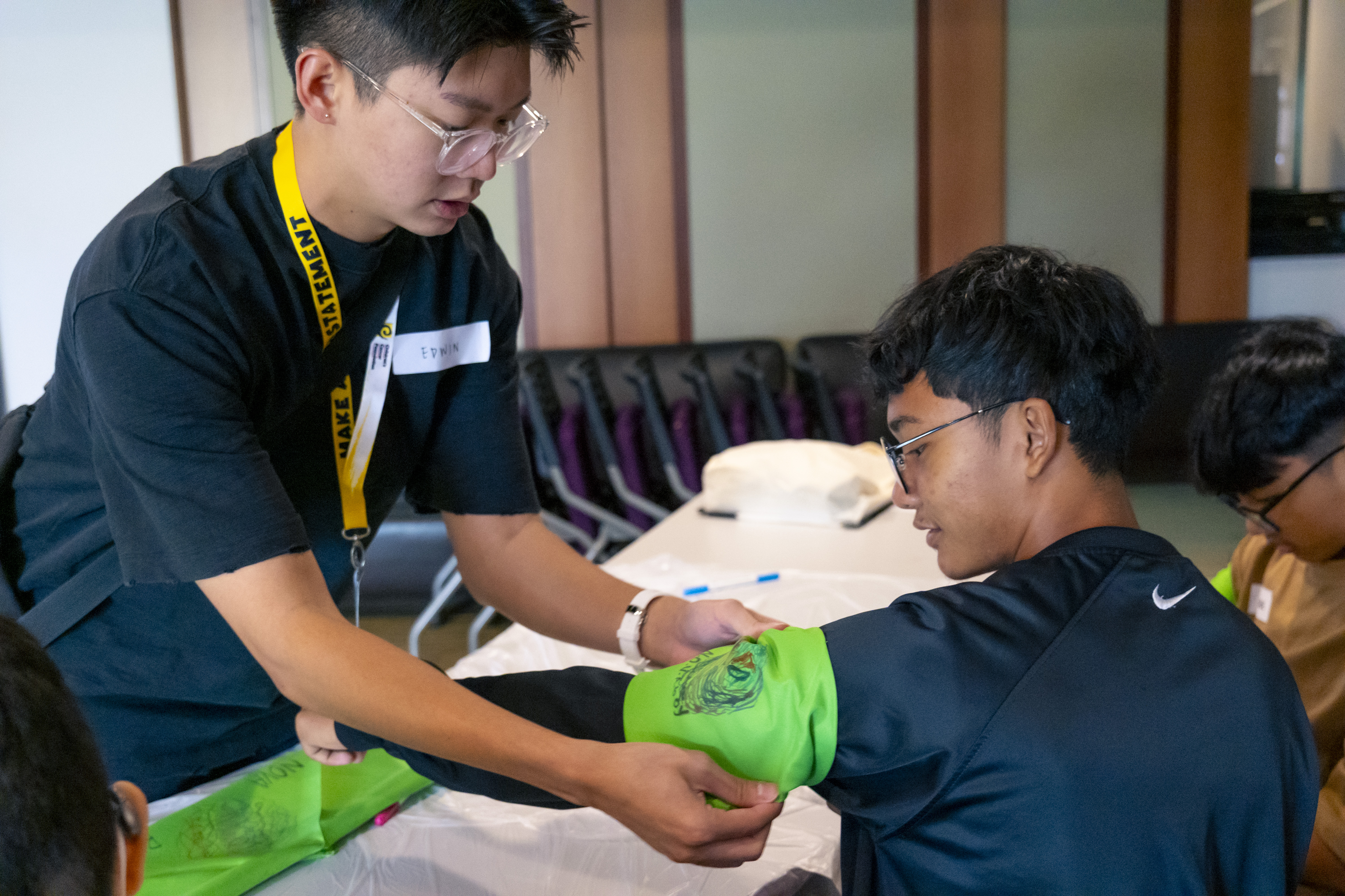 Edwin Lim Wang Ying helps a teammate tie the green bandana around his arm, with the team’s chosen name and custom-designed logo proud