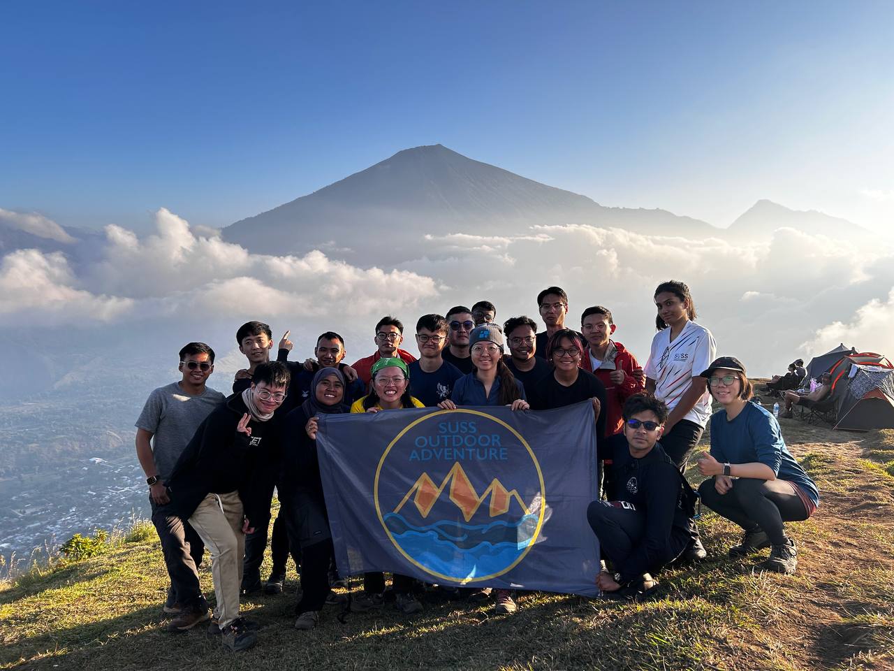 All 18 members gathered for a group photo at their campsite on Pergasingan Hill, proudly holding up the ODAIG flag with the majestic Mount Rinjani in the background.