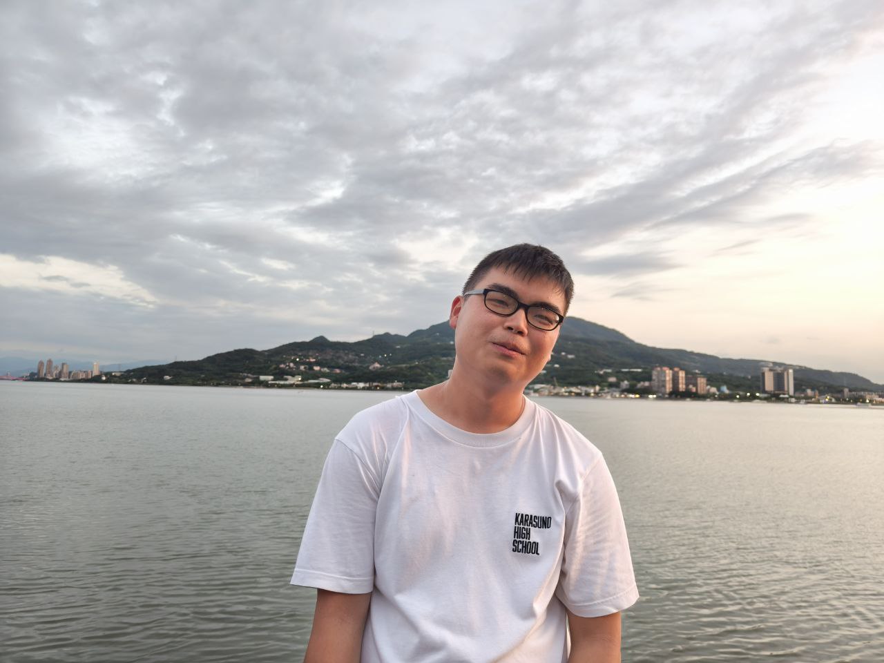 Ho Jing Yang (Year 3, Social Work Student) smiling brightly at the seaside against the serene backdrop of Tamshui Harbour (淡水漁人碼頭).