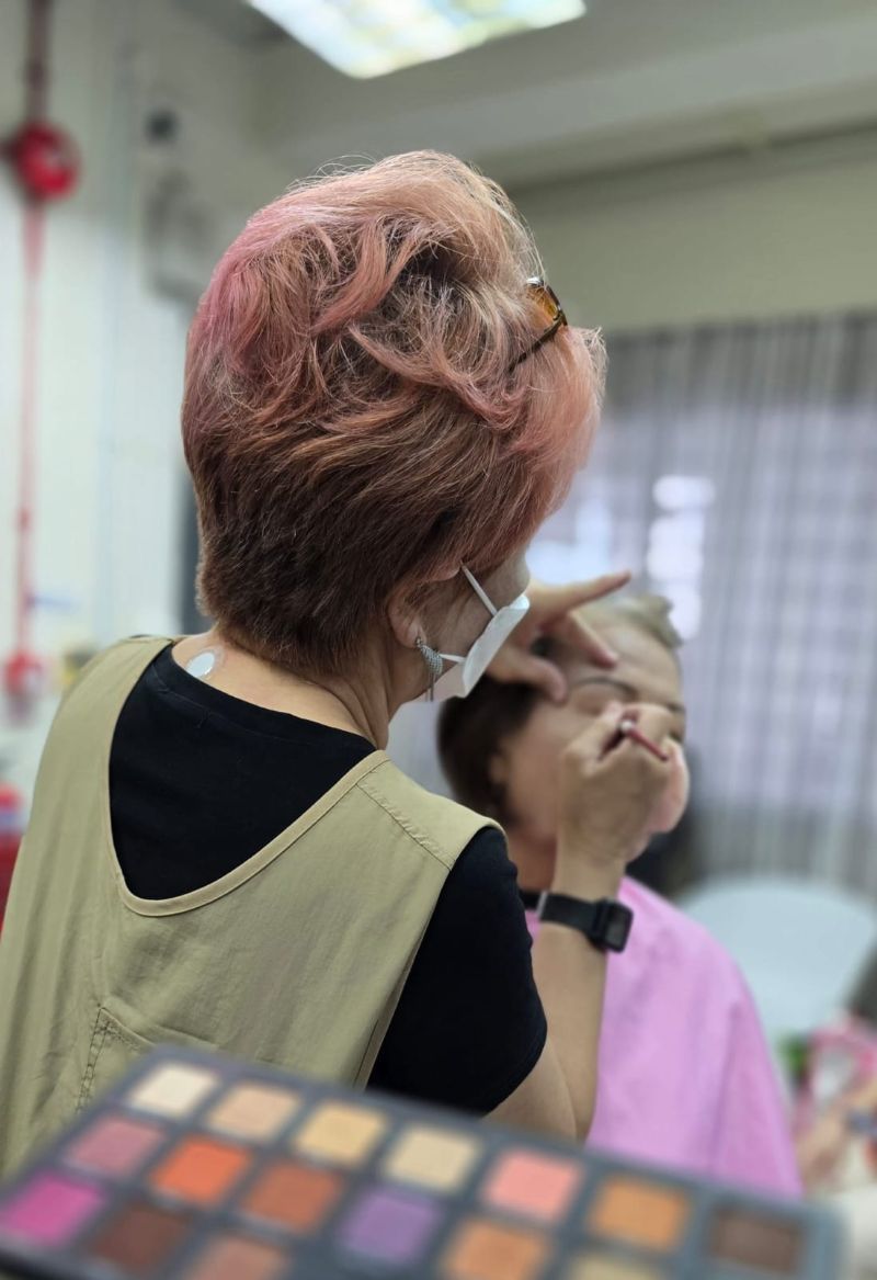 One of the volunteer makeup artist helping the beneficiary do their makeup One of the volunteer makeup artist helping the beneficiary do their makeup