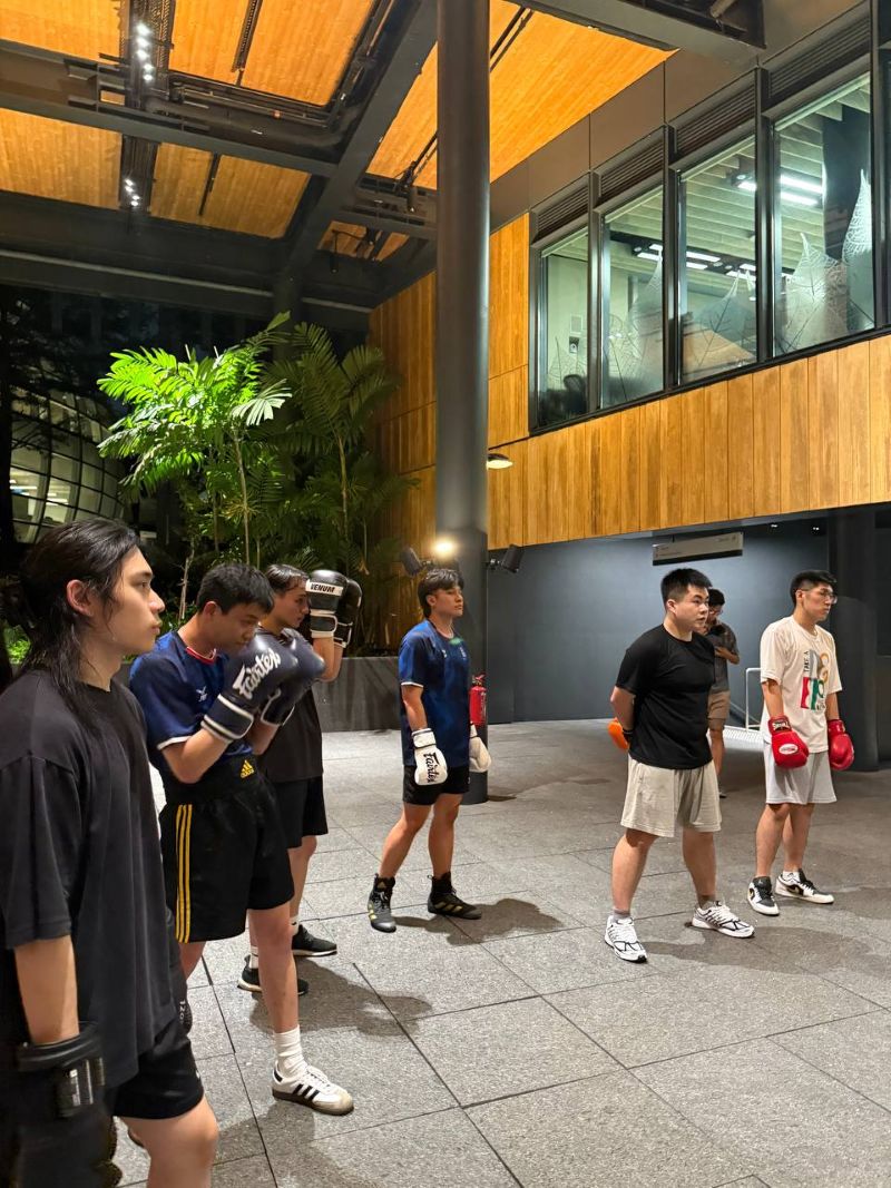 Participants- observing Participants from SUSS, SMU and SIM wearing boxing gloves stand in a line during what appears to be a boxing training session