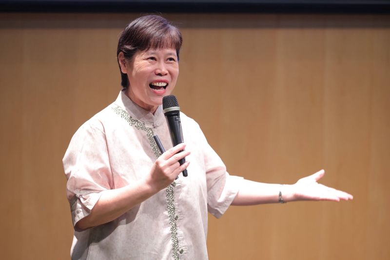 Person speaking into a microphone on stage