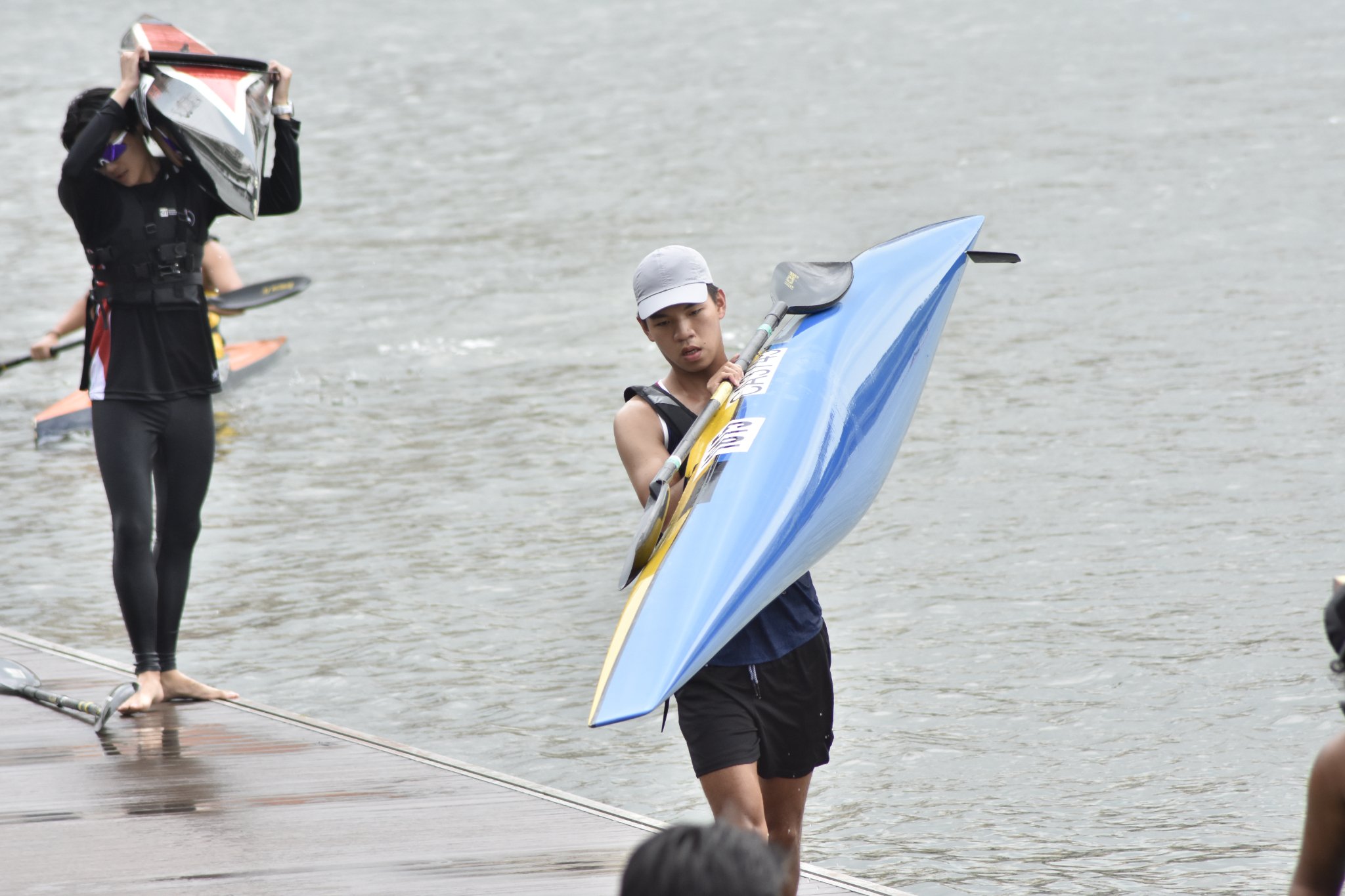 SUSS Canoeing Novice Men’s K1 athlete preparing for the portage segment of the 16km race. SUSS Canoeing Novice Men’s K1 athlete preparing for the portage segment of the 16km race.