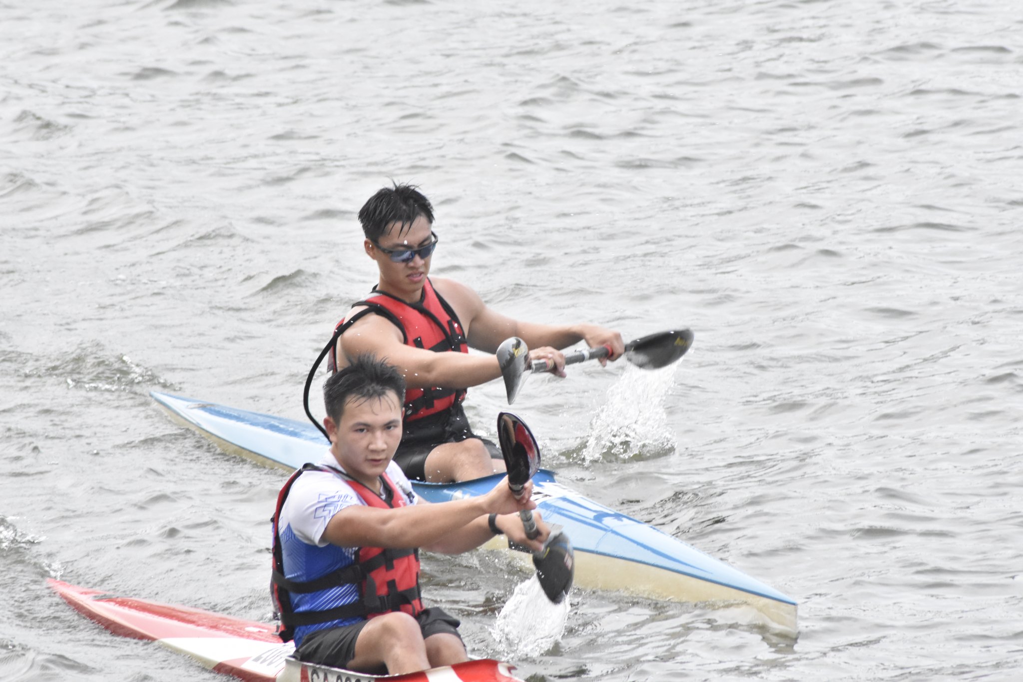 SUSS Canoeing Senior Men’s K1 athlete racing closely alongside a competitor during the event. SUSS Canoeing Senior Men’s K1 athlete racing closely alongside a competitor during the event.