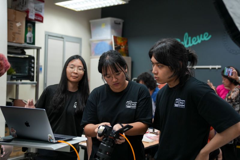Yuan Ting (middle) guiding and reviewing the photos taken by Carina (left) and Zack (right)