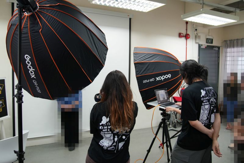 Zeti (left) shooting for the beneficiaries while Zack (left) checks for the photos in a monitor screen