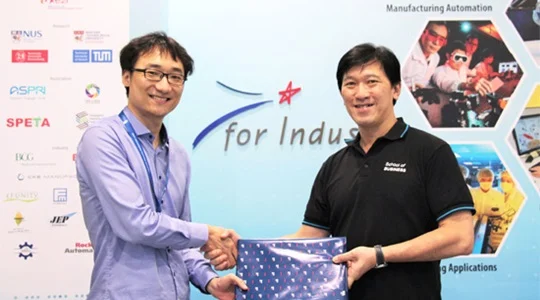 Prof Lee Pui Mun, Dean, School of Business, SUSS, presenting a token of appreciation to Mr Wang Yi , Factory Manager, Model Factory at SIMTech