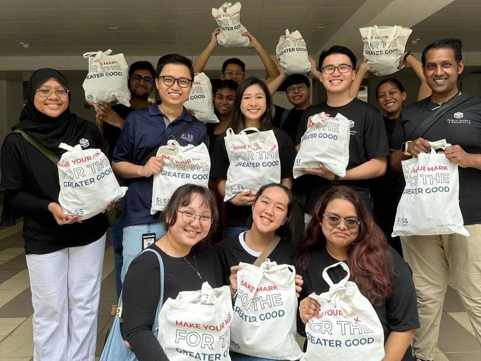 SUSS Public Safety and Security Students huddle for a group photo before distributing the hand-packed donation bags.