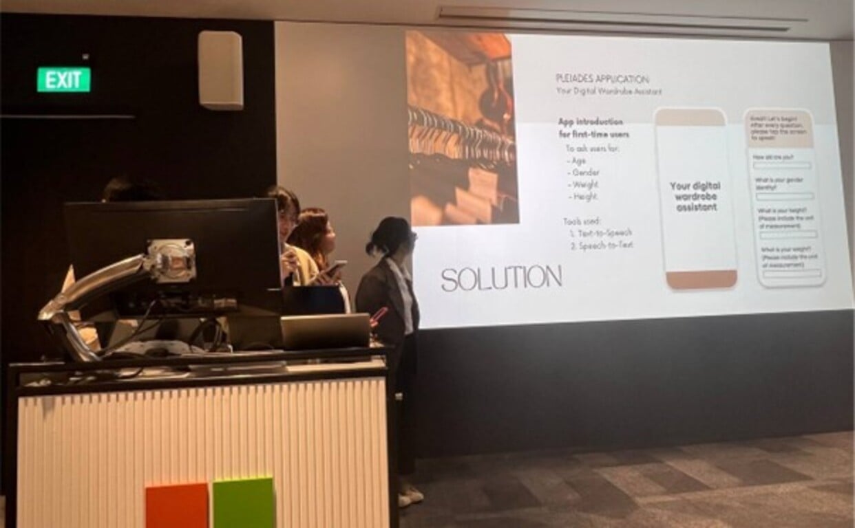 Team Pleiades presenting their innovative solution that combines AI technology with seamless navigation controls to assist individuals with visual impairment to pick their outfits.