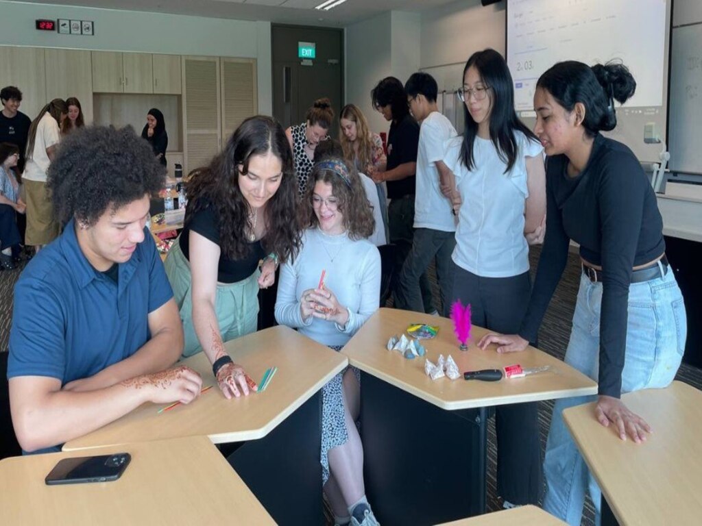 University of Nebraska-Lincoln students playing a game of pickup sticks and engaging in lively conversations.