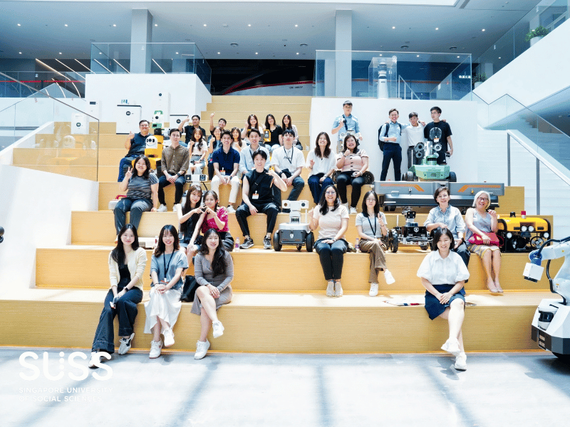 Group of people sitting on the stairs posing for a photo