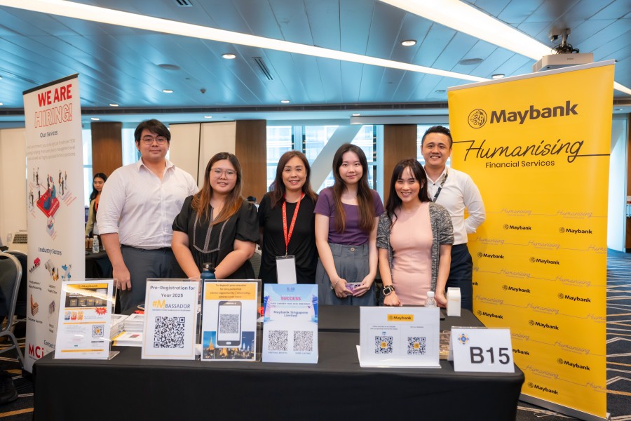 Maybank staff posing at SUSS career fair booth promoting employment opportunities to SUSS Students.